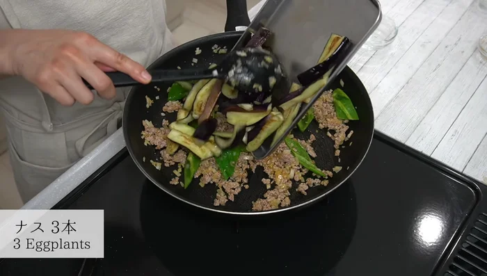 Add the cooked eggplant back into the pan. Stir-fry everything together for about 30 seconds.