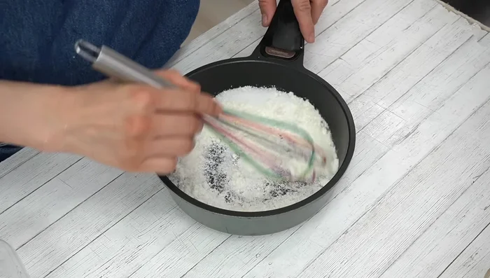 In a pot, combine granulated sugar and the strong flavor (presumably a pre-made annin tofu mix). Mix well using a silicone or rubber spatula to avoid scratching the pot.