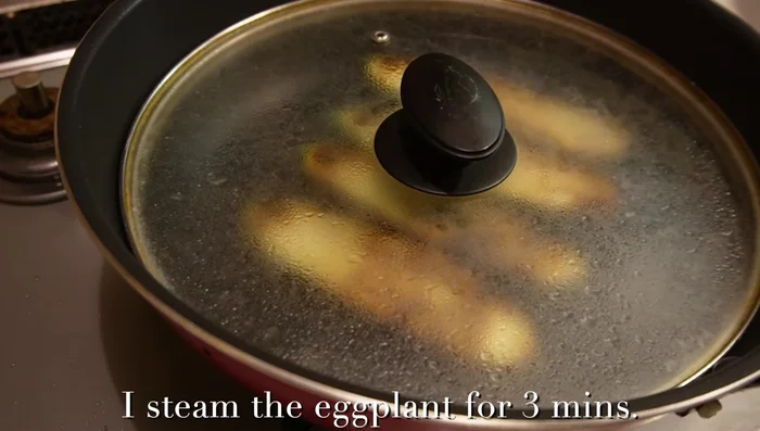 Steam eggplant in pan with water until soft (297.639).