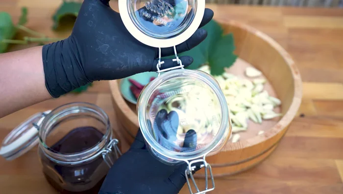 Pack an airtight container with grape leaves, rakkyo, chili peppers (adjust to your spice level), and amazuke. Submerge rakkyo completely.