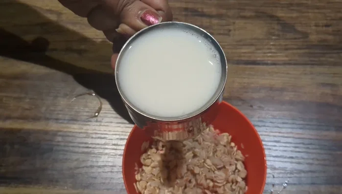 Pour 1 cup of boiled milk over the rice and oats. Stir gently to ensure everything is submerged.