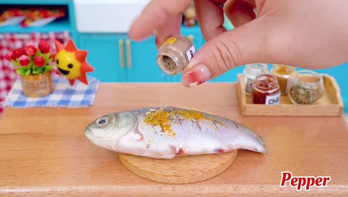 Marinate the fish with oregano leaves, salt, turmeric powder, and pepper.