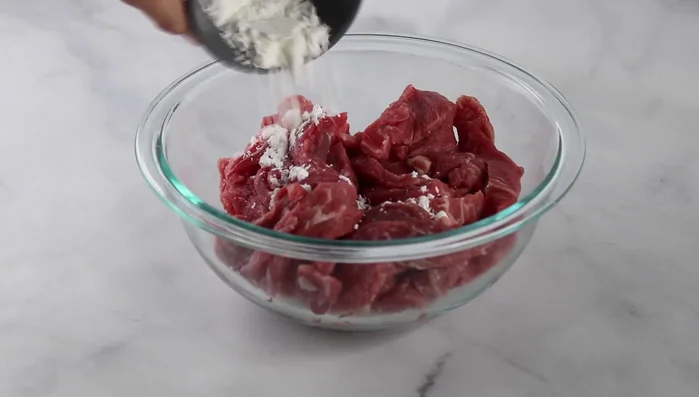 Prepare the beef: Toss flank steak in cornstarch.