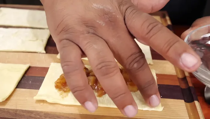 Fold the pastry over the filling, pressing the edges to seal. Use a fork to crimp the edges.