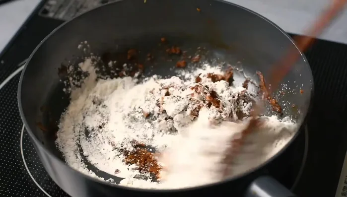 Once onions resemble a paste, add flour and mix well. Add toasted spices.