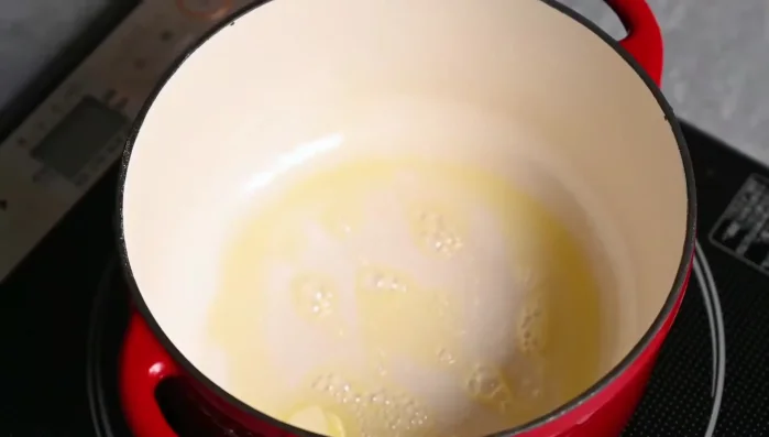 In a large pot, melt butter. Seal bite-sized pieces of beef shoulder. Add chopped carrots and potatoes.
