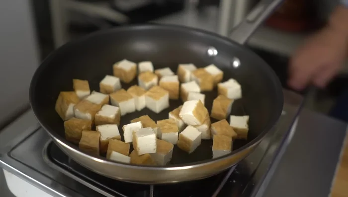 Add the fried tofu to the pan and fry until lightly browned on all sides, turning occasionally. This gives a slightly chewy texture.
