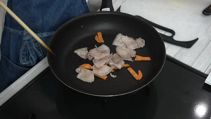 Once the meat is cooked, add the cabbage and bell peppers. Stir-fry.