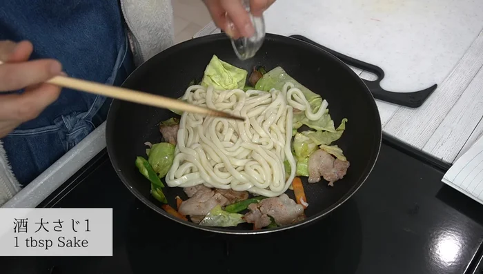 Add the boiled udon noodles. Pour more sake, stir-fry while gently breaking up the noodles.