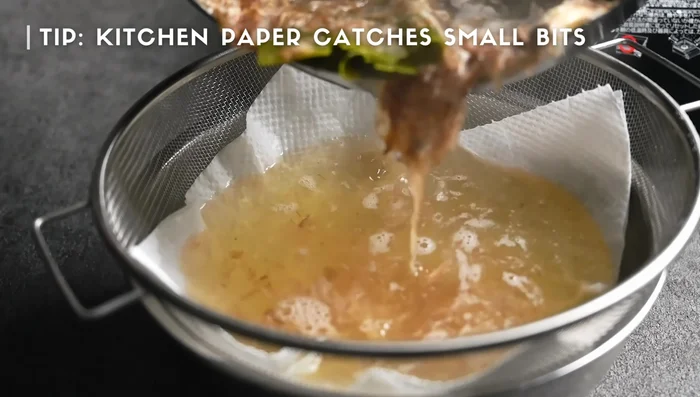 Strain the dashi through a strainer lined with kitchen paper to remove solids and obtain clear broth.