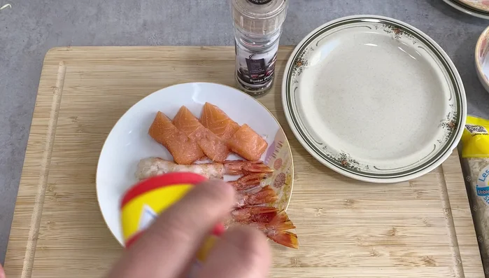 Season shrimp and salmon lightly with salt and pepper.