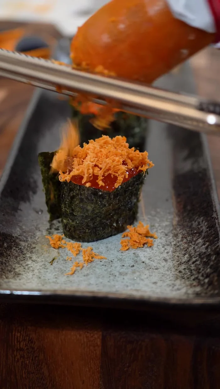 Garnish with Ankimo: Top the Ikura with the grated ankimo.