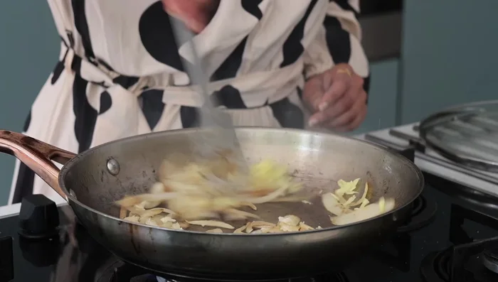 Sauté white onions in sesame oil until translucent, then add garlic and ginger paste. Add bell peppers and broccoli.