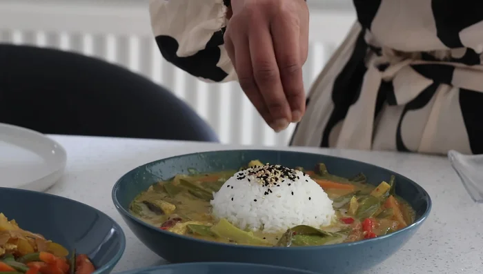 Combine rice with coconut curry; garnish with sesame seeds. Serve noodles and stir-fry with spring onions.