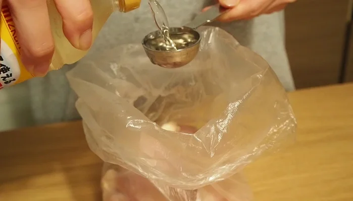 Marinate chicken in vinegar and sugar in a plastic bag for 15 minutes.