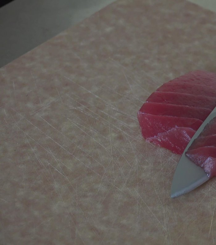 Prepare Sashimi: Slice tuna, salmon, and yellowtail thinly using a sharp knife.