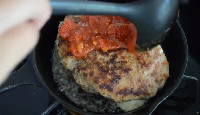 Pour the tomato sauce over the hamburger steak.