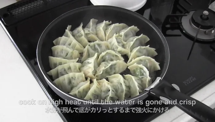 Uncover and cook on high heat until water is gone and gyoza are crispy.