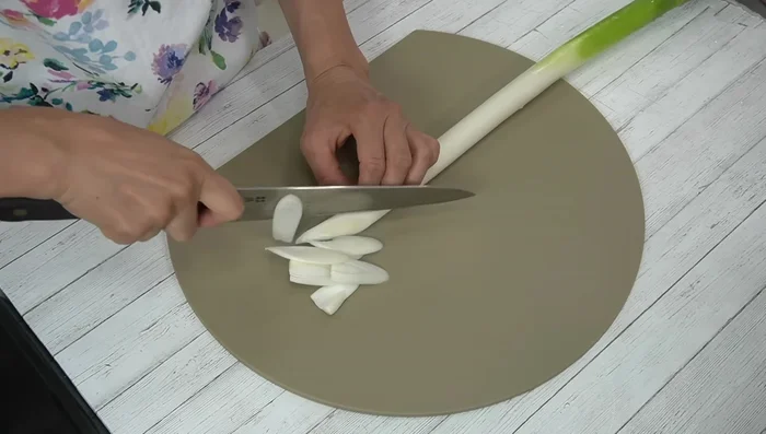 Cut green onions diagonally into approximately 5mm wide pieces. Add the green parts to a bowl.