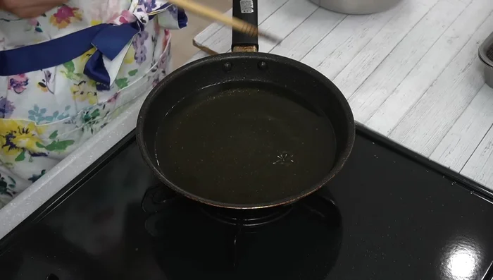 Using chopsticks or a ladle, carefully place small amounts of the mixture into the hot oil. Spread it slightly, then gently shape it.
