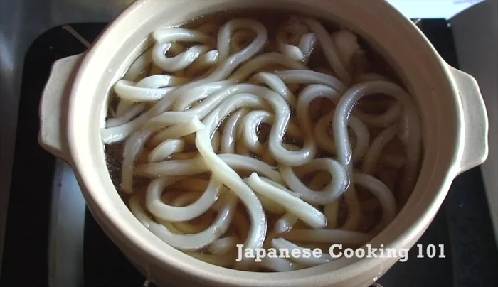 Add prepared toppings: carrot, shiitake mushrooms, shrimp, kamaboko, and cooked spinach.