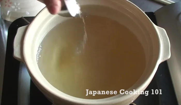 In a nabe pot, add dashi broth and seasonings: salt, soy sauce, sake, and mirin. Stir.