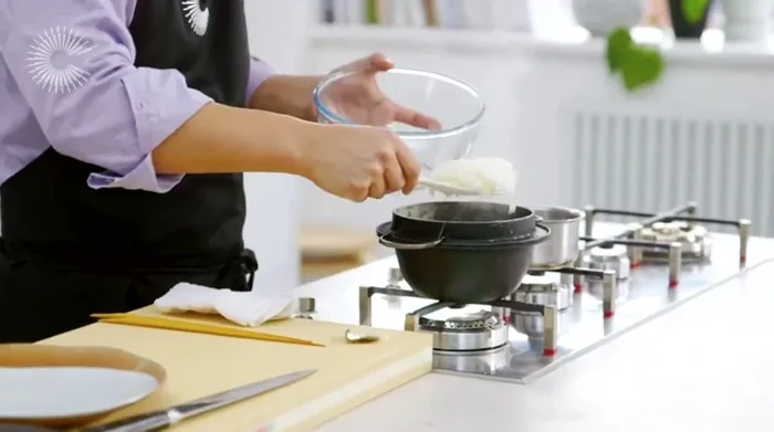 Once the rice is cooked, transfer it to a bowl and gently mix in the sushi vinegar, using a rice paddle or spatula to avoid breaking the grains. (126.849)