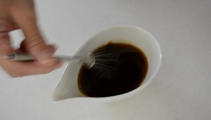 Pour 3 tablespoons of abura soba sauce into individual ramen bowls.