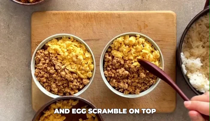 Scoop cooked rice into serving bowls. Place the scrambled eggs on top of the rice and garnish with chopped scallions.