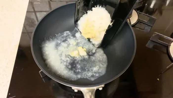 In a cold frying pan, add the grated daikon radish and ginger. Add soy sauce, mirin, sugar, and salt. Add a little water.