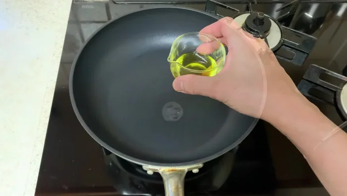 Heat olive oil in a frying pan. Add meatballs and press down firmly to ensure even browning. Steam-fry for 3 minutes with the lid on.