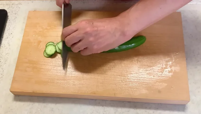 Cut cucumber into small pieces. Place in a plastic bag, add a light sprinkle of salt, and let sit for 5 minutes to soften.