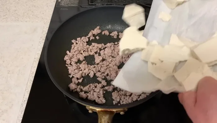 Add the tofu: Add the slightly drained tofu to the pan and stir-fry until heated through.