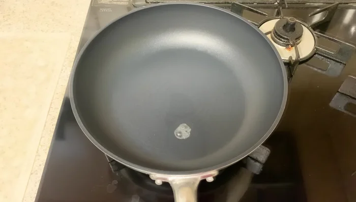 Heat sesame oil in a frying pan using the water drop technique. Once hot, add the shiitake burgers meat-side down, pressing firmly.