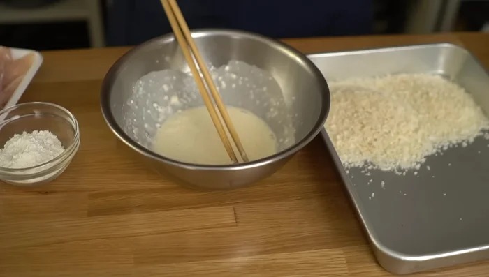 Coat the chicken: Coat each chicken fillet in flour, then the batter, and finally in panko breadcrumbs (214.4). Let it rest for about 5 minutes to allow the batter to set (294.199).