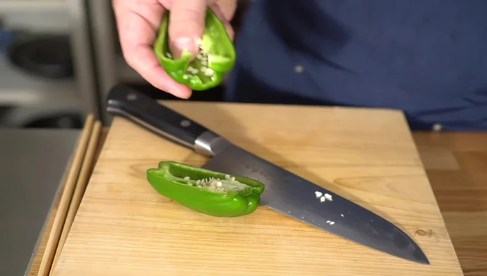 Halve the green peppers lengthwise, remove seeds and stems, then slice thinly.