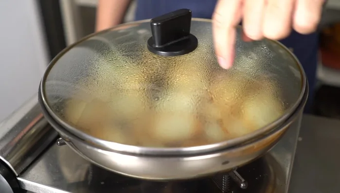 After approximately 56 minutes of steaming the potatoes, wipe any water droplets from the lid before removing it to prevent splattering.