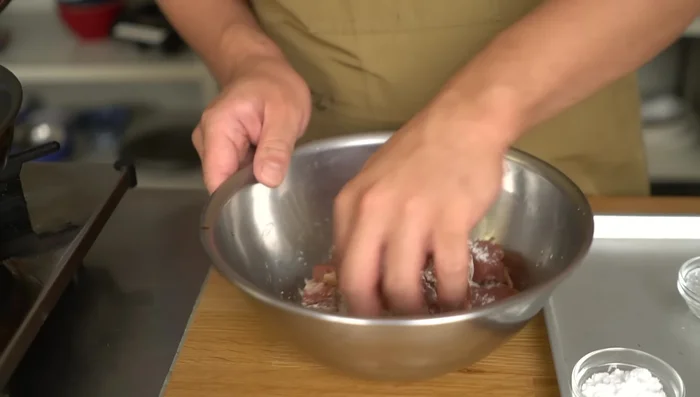 Prepare the batter: First coat the marinated pork in flour, then lightly coat with potato starch, and finally coat thoroughly with potato starch.