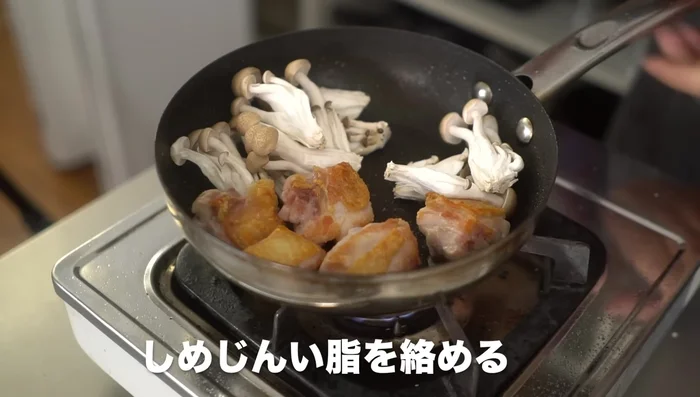 Roughly break up the sardines and add them to the pan, mixing them with the chicken oil. Gather the sardines and create a space.