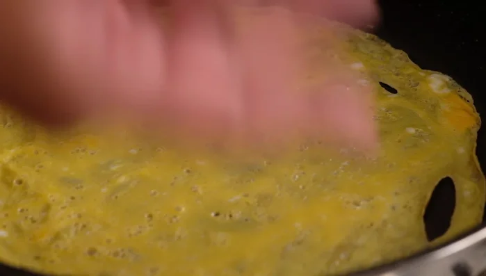 Once the top is dry and doesn't stick to your fingers, carefully lift and remove the cooked omelette.