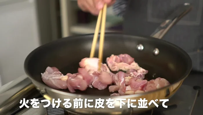 Heat sesame oil in a pan. Add chicken skin-side down, sprinkle with a pinch of salt, and cook until crispy.