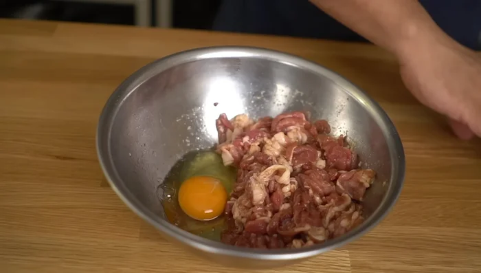 Beat an egg and add it to the marinated pork. Mix gently.