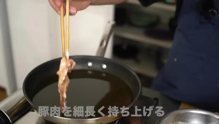 Carefully add the pork pieces to the hot oil, ensuring not to overcrowd the pan.