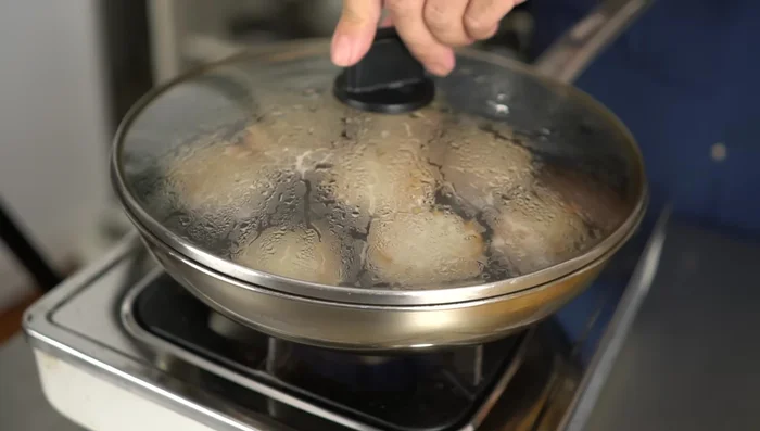 After 3 minutes, check the meatballs. If water is accumulating, slightly increase the heat. Both sides should be lightly browned and cooked through.