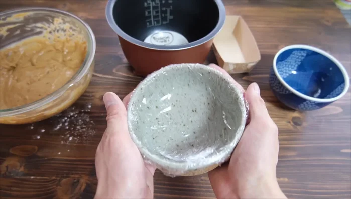 Line a container (e.g., cake mold, small bowl) with plastic wrap. Pour the batter into the container, gently tapping to remove air bubbles.