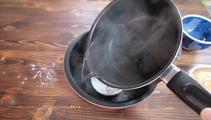 Place the prepared container(s) onto the plate in the rice cooker. Pour hot water into the rice cooker until the water level is about 2cm high.