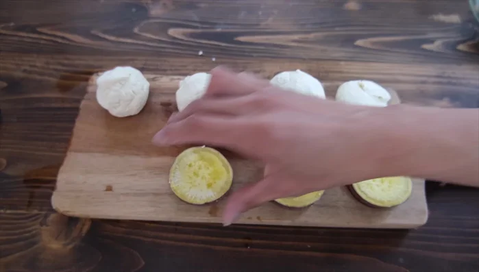 Place a sweet potato piece in the center of each dough portion. Top with 25g of red bean paste.
