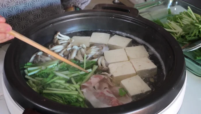 Once boiling again, dip pork slices into the simmering broth until cooked through (longer than beef).
