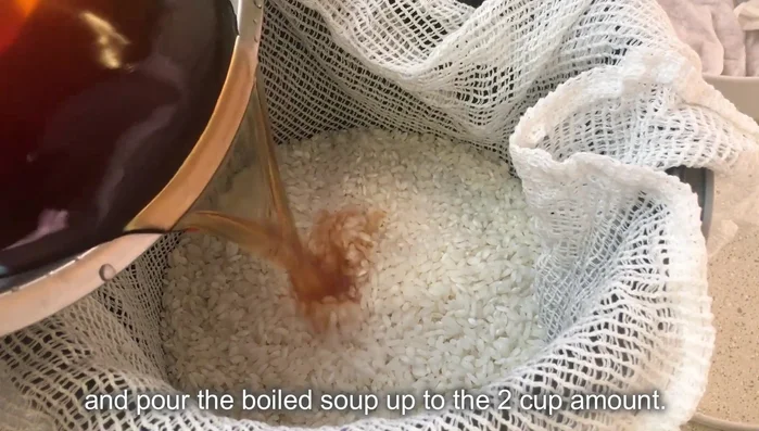 Prepare the rice cooker. Add the washed rice to the rice cooker. Add the reserved adzuki bean cooking liquid (or water if needed) up to the 2-cup line.