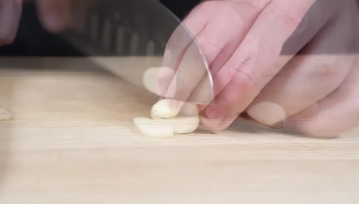 Prepare garlic: Slice two cloves thinly. One for garlic chips, the other minced for the rice.